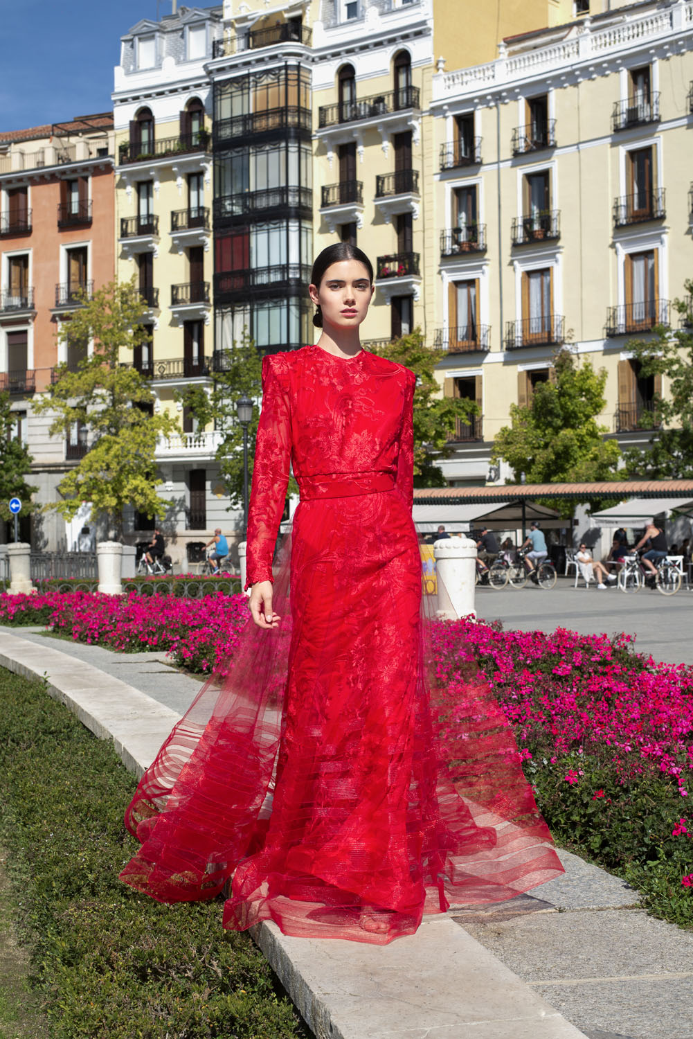Woman in a red gown and tulle overskirt. 25, image 1