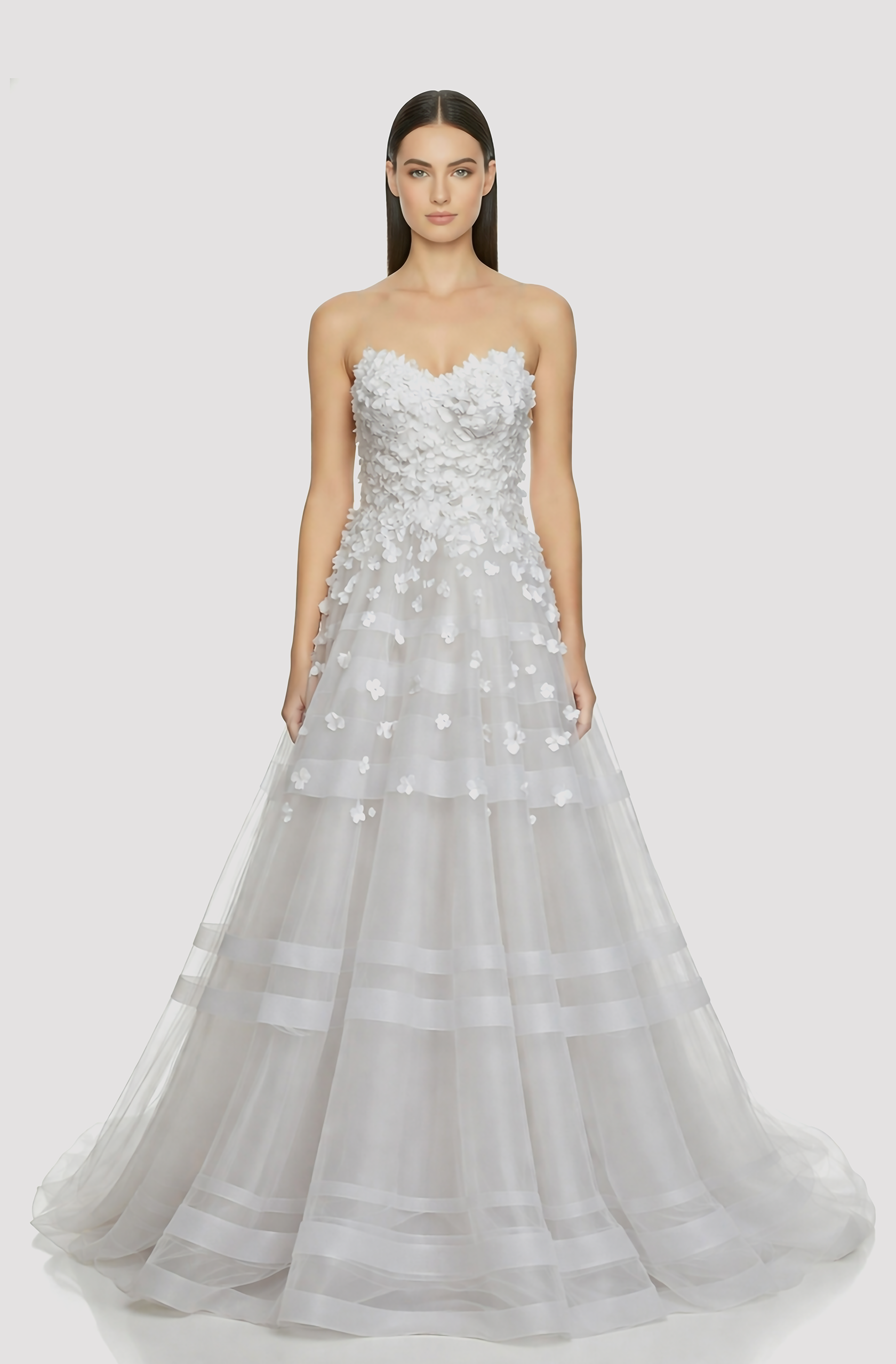 Front view of a woman in an Off-white tulle ball gown with cascading 3D flowers on the bodice and concentric horsehair accents on the skirt 5, image 1