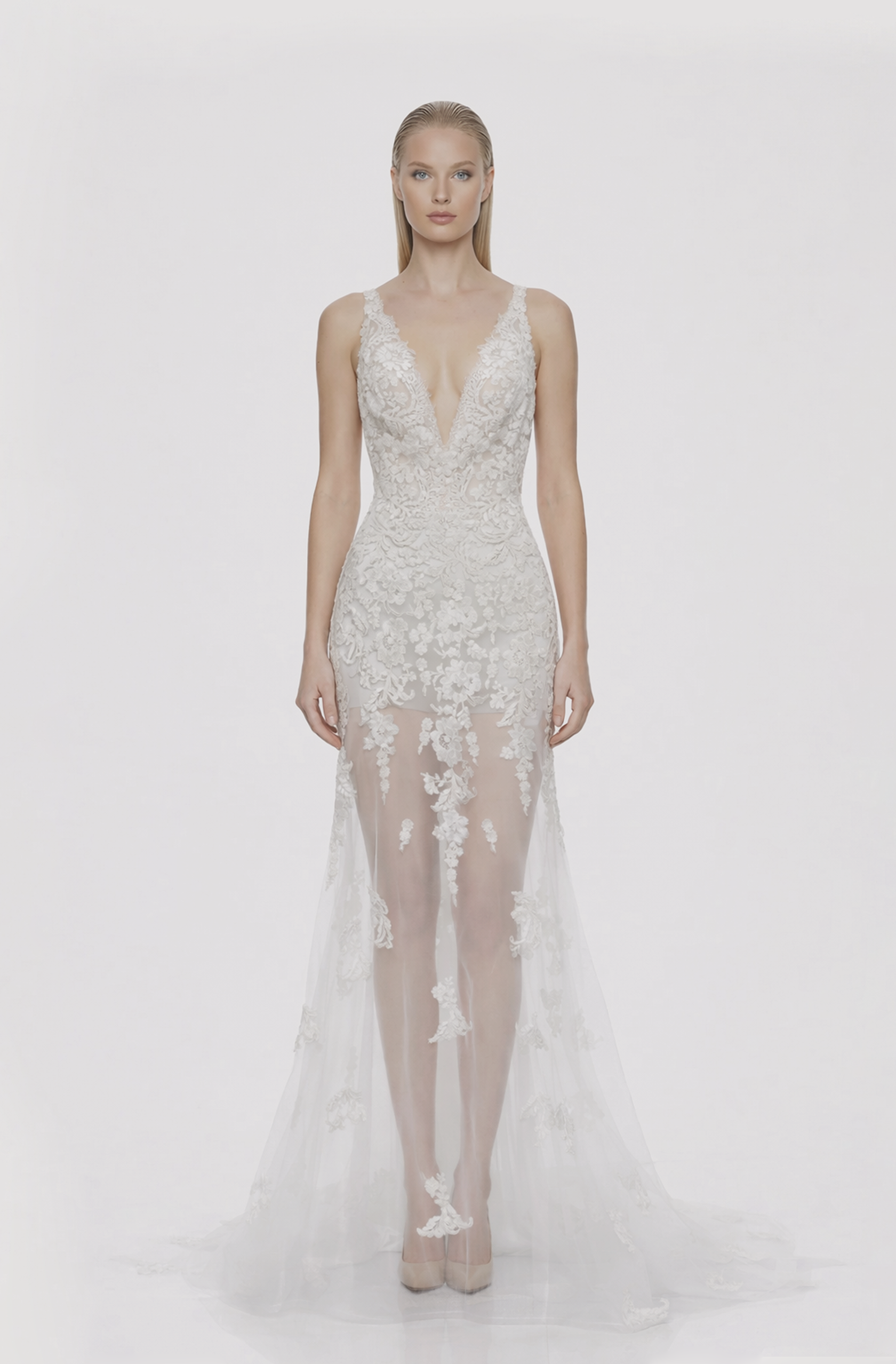 Front view of a woman in an Off-white tulle v-neck mermaid gown with see-through skirt embellished with cascading corded lace 7, image 1