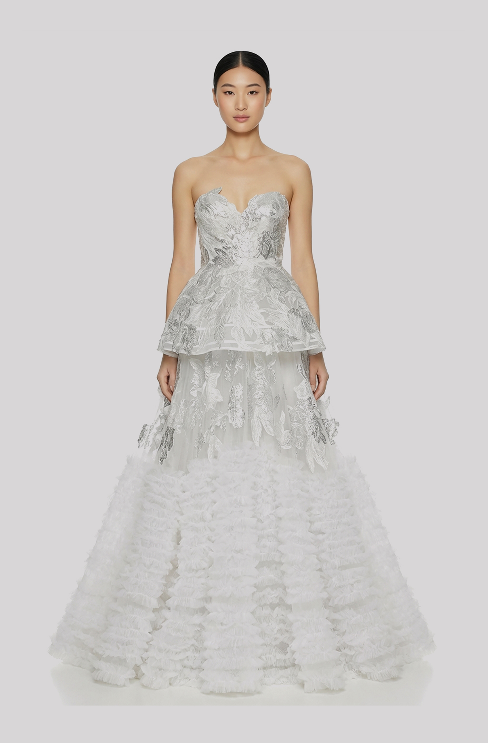 Front view of a woman in an Off-white, two-piece silver 3D lamé floral couture ensemble with a structured corseted top and a layered ruffled tulle ball skirt 38, image 1